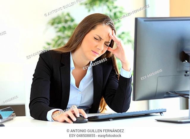 Businesswoman suffering headache at work using a desktop computer in the office