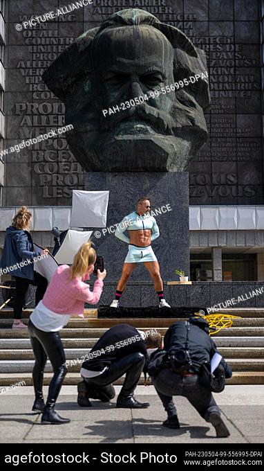 04 May 2023, Saxony, Chemnitz: Model Tom Simon shows an outfit from the bodywear collection of the manufacturer Wonneberger in front of the Marx Monument in...