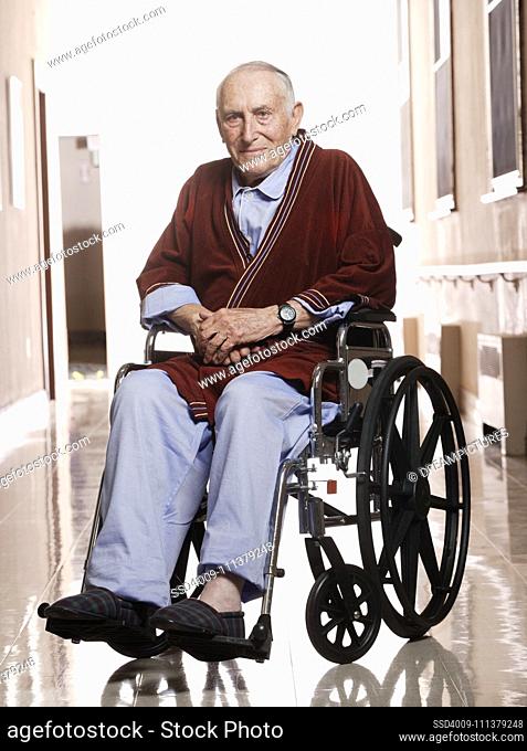 Elderly man smiling for the camera in a wheelchair