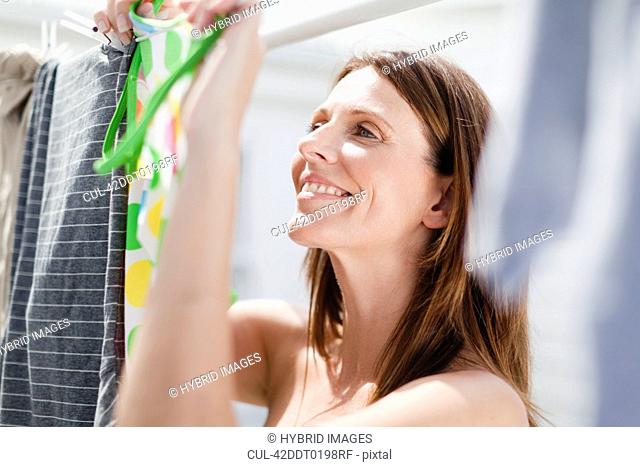 Smiling woman hanging laundry
