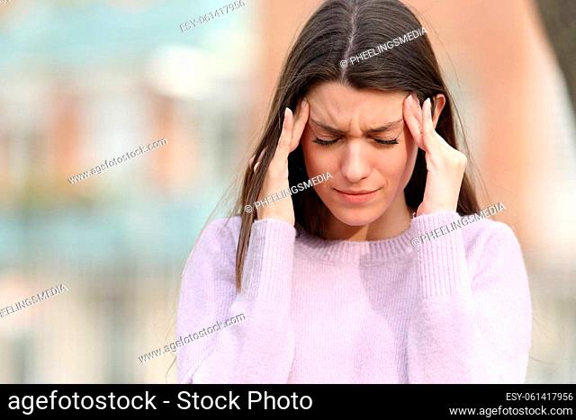Teen suffering head ache in the street