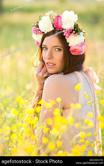 Woman with flower wreath on a meadow