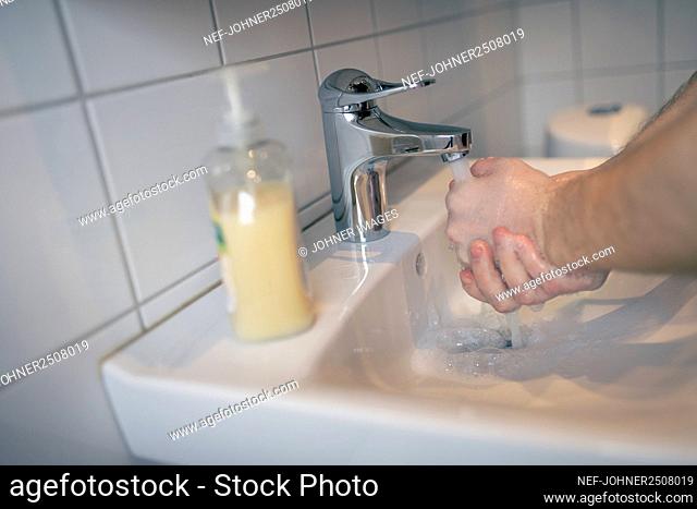 Man washing hands in bathroom