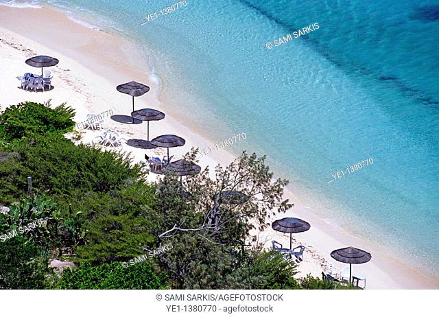 Sun umbrellas dotted along the white sand beach on Amedee Island, New Caledonia