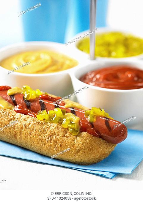 A hot dog with ketchup, mustard and pickle relish