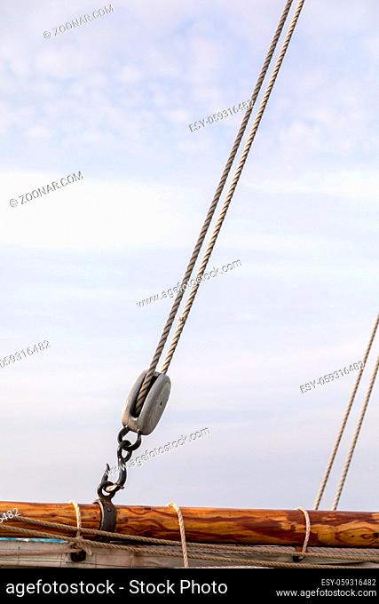 Part of the old sailing boat with ropes, hook and pulley