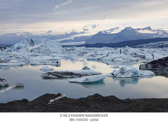 Icebergs being reflected on the calm Joekulsarlon glacial lake, Iceland, Europe