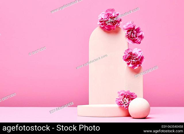 podium with flowers and elegant arch on pastel pink background. stage for presentation cosmetic or beauty product. minimal fashion design. copy space