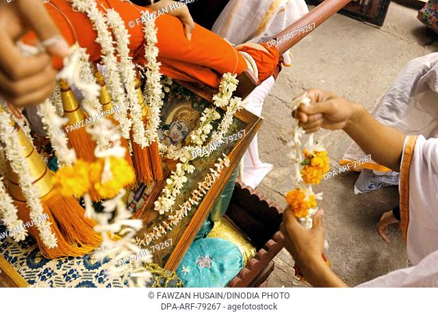 Devotees decorate Krishna 'palkhi' before the procession , Poona , Maharastra , India