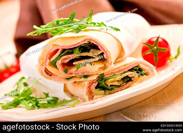 Delicious tortillas stuffed with bacon and colorful arugula salad