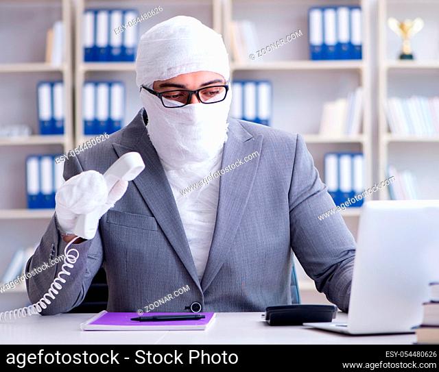 Bandaged businessman worker working in the office doing paperwork