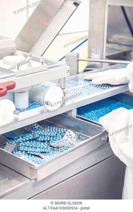 Technician monitoring birth control pill packaging machine