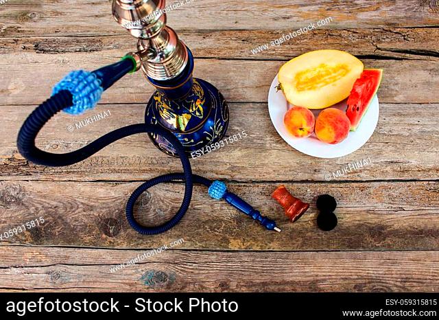 Hookah, fruit, berries on old wooden background