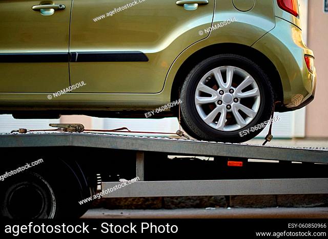 Car fixed on tow truck with metal winch and hooks. Vehicle problem on road. Closeup cropped image