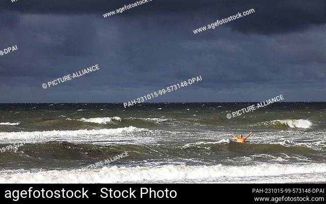 15 October 2023, Rostock-Warnemünde: A man jumps into the Baltic Sea in stormy weather in Rostock-Warnemünde. Photo: Frank Molter/dpa