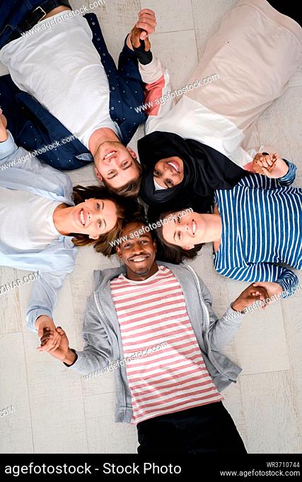 a top view of a diverse group of people lying on the floor and symbolizing togetherness