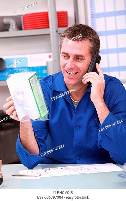 Man checking product details by phone in a plumber's merchants
