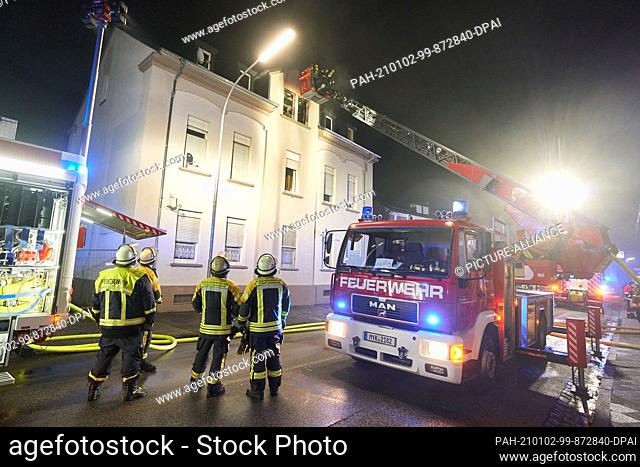02 January 2021, Rhineland-Palatinate, Bendorf: Firefighters fight an apartment fire from a turntable ladder. One person died in the attic apartment