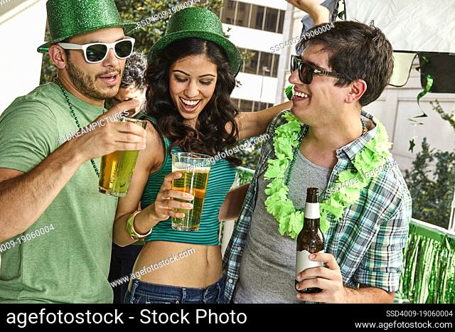 Group of friends hanging out on balcony of bar enjoying the St Patrick's Day festivities