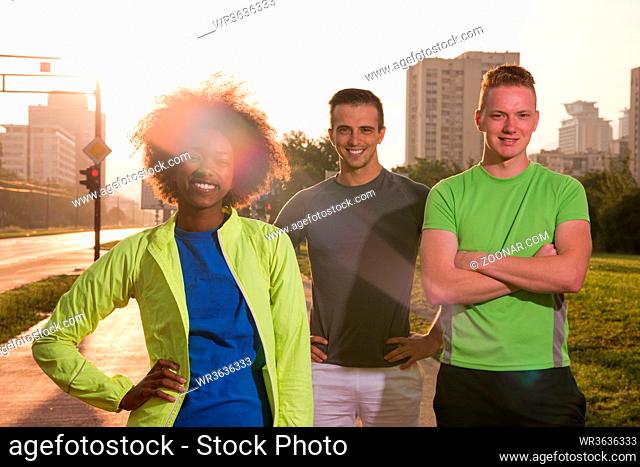 Portrait of multi-ethnic group of young people on the jogging beautiful summer evening as the sun sets over the city
