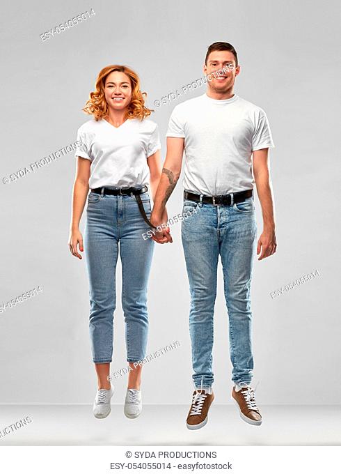 happy couple in white t-shirts jumping or hanging
