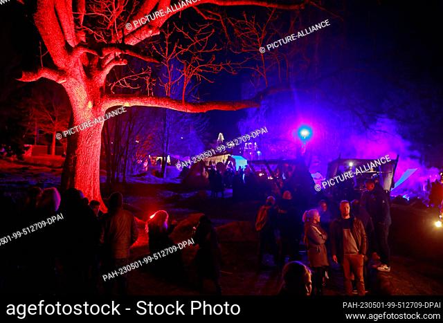 30 April 2023, Saxony-Anhalt, Schierke: Colorfully illuminated is the medieval market for the Walpurgis Festival in the Schierk spa park