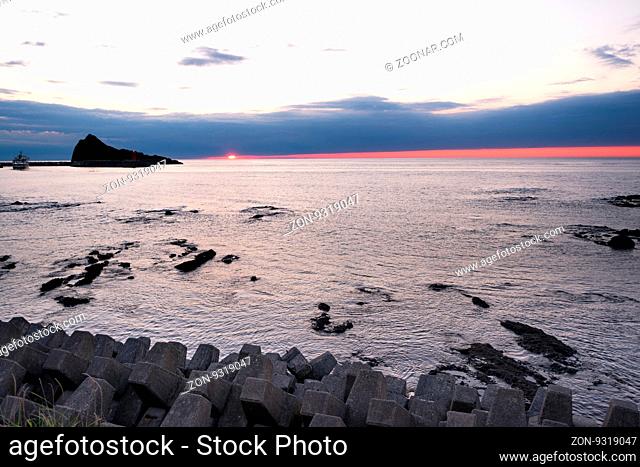 rock beach near tranquil sea at sunrise