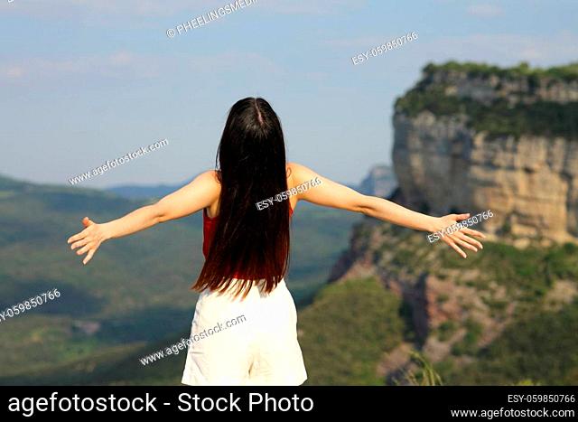 Woman outstretching arms contemplating in the mountain