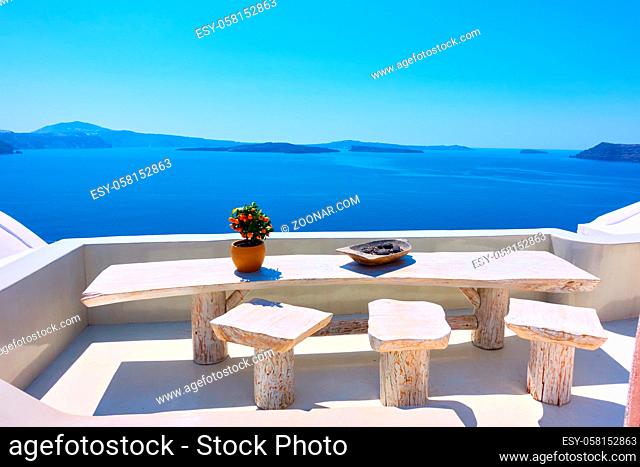 View of the Aegean sea from Santorini island with table and seats in the foreground, Greece. Greek landscape. Travel destination