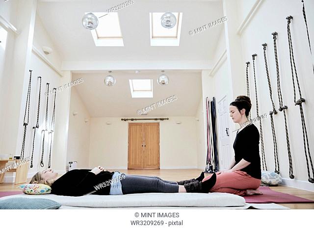 Woman lying down on her back fully clothed in preparation for a Thai massage