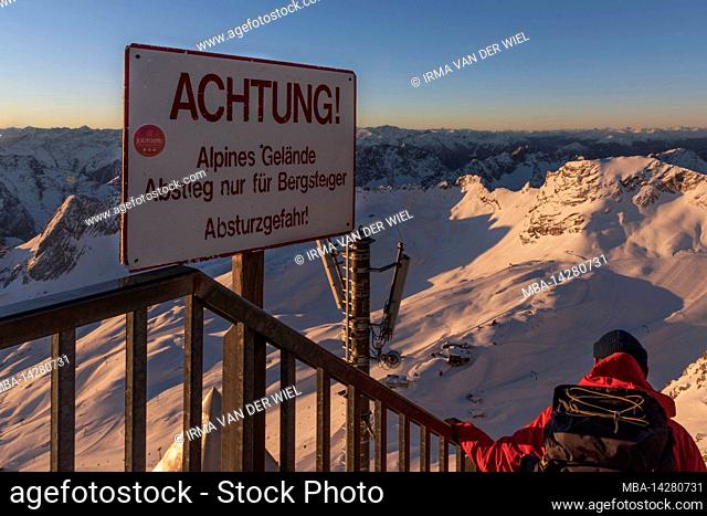 Morning atmosphere on the Zugspitze, sunrise on Germany's highest mountain Top of Germany. Warning sign Attention alpine terrain descent only for mountaineers...