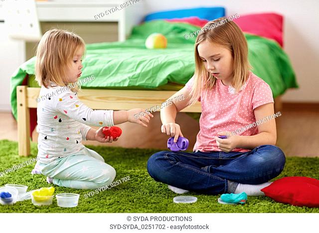 sisters with modelling clay or slimes at home