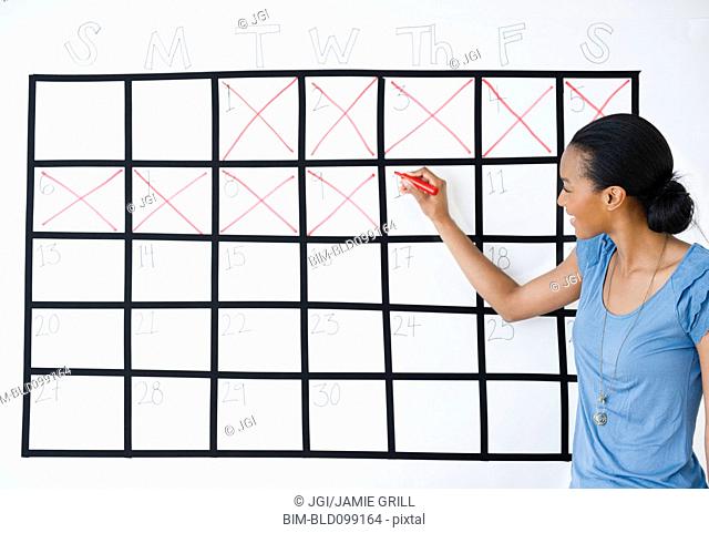 Black woman marking the days off calendar