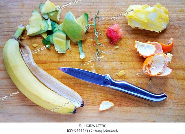 Selection of peeled fruits on a wooden cutting board with a silver metal cutting knife. Eating healthy Food backgrounds and textures.Copy space