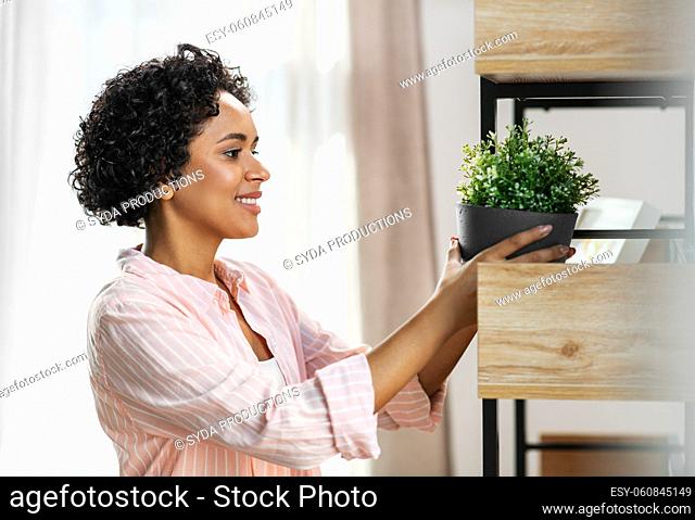 woman decorating home with flower or houseplant