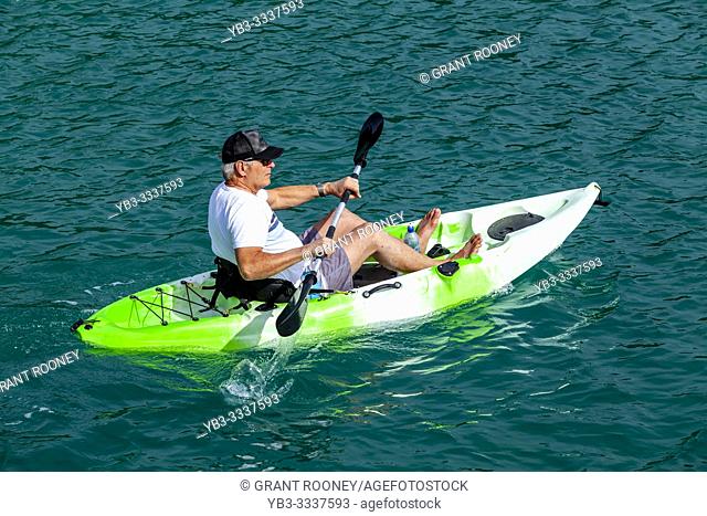 A Senior Male Kayaking At Otehei Bay, The Bay Of Islands, North Island, New Zealand