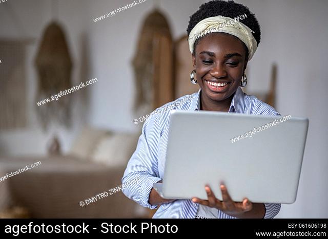 Connected. Dark-skinned smiling woman witha laptop