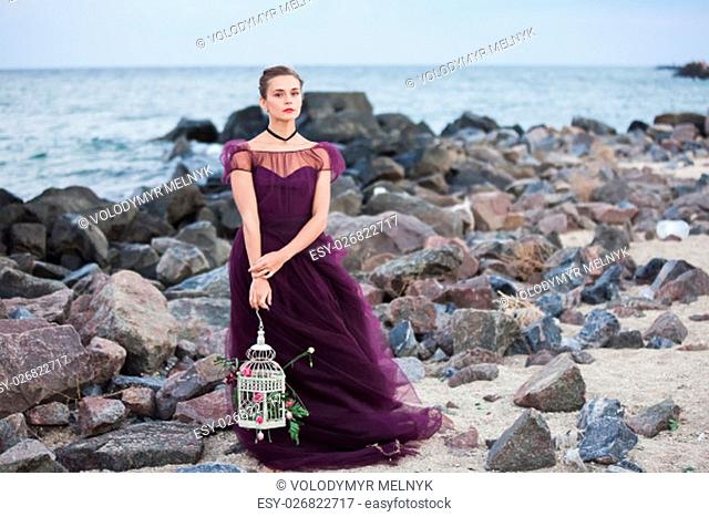 The wedding day at the sea. Young romantic woman posing on the beach watching the sunset