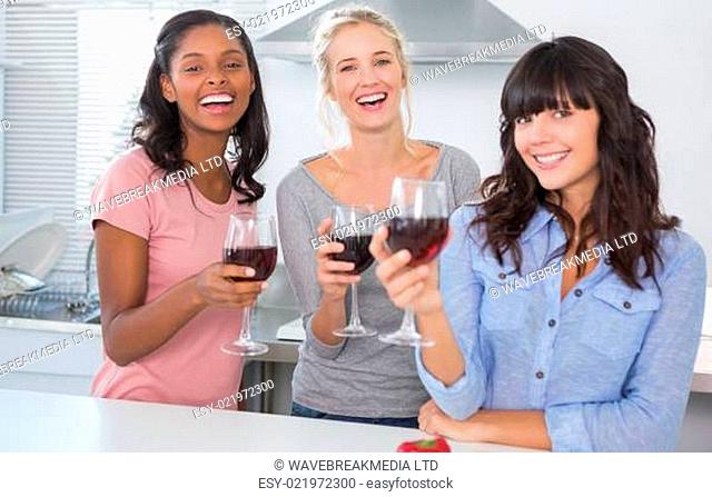 Cheerful friends enjoying glasses of red wine