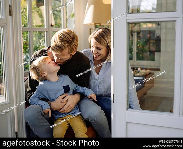 Happy and affectionate family in sunroom at home