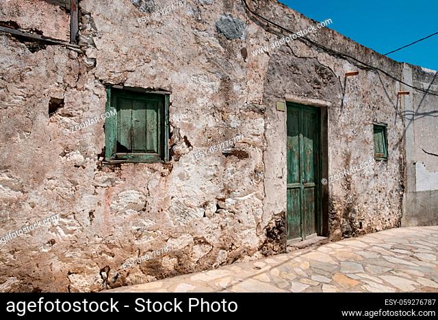 old house with wooden door and weathered facade in rural village