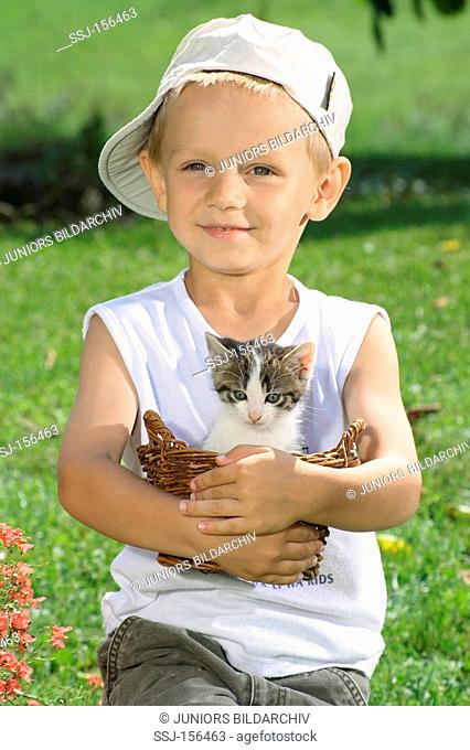 small boy with kitten in a basket