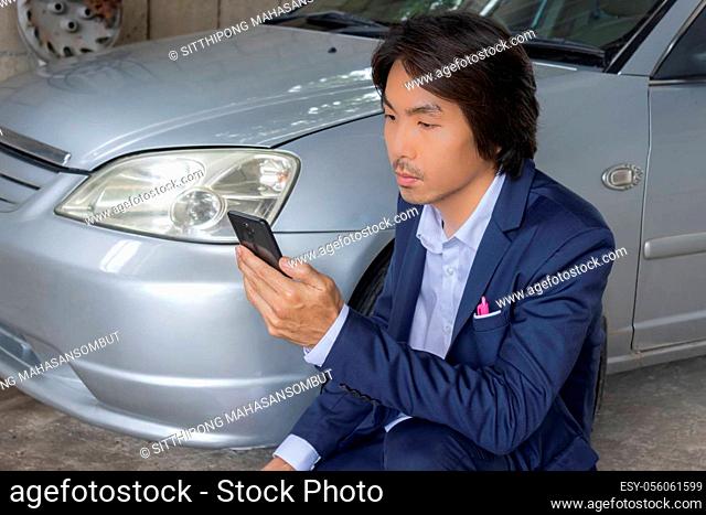 Asian Insurance Agent or Insurance Agency in Suit See Smartphone and Inspecting Car Crash from Accident for Claim at Outdoor Place
