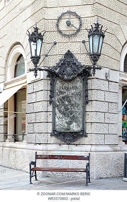 TRIESTE, ITALY - OCTOBER 14, 2014: Famous Pharmacy Farmacia Serravallo Iron Clock With Lanterns at Corner in Trieste, Italy