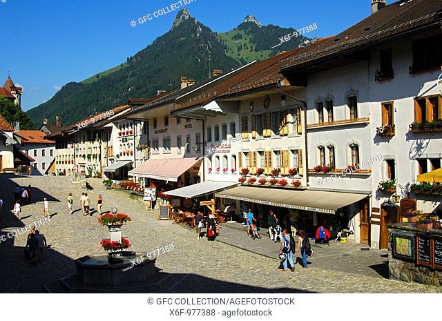 Main street in the medieval cheese town of Gruyère, in the backMt  Dent de Broc, Mt  Dent du Chamois, Cantone of Fribourg, Switzerland