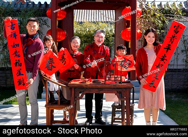 Happy family write Spring Festival couplets to celebrate the New Year