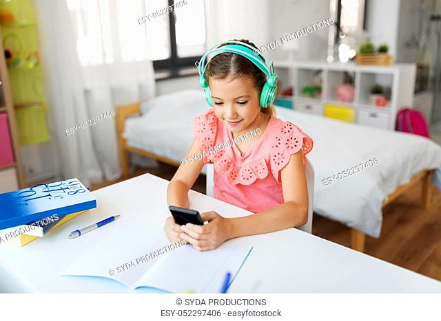 girl in headphones listening to music on cellphone