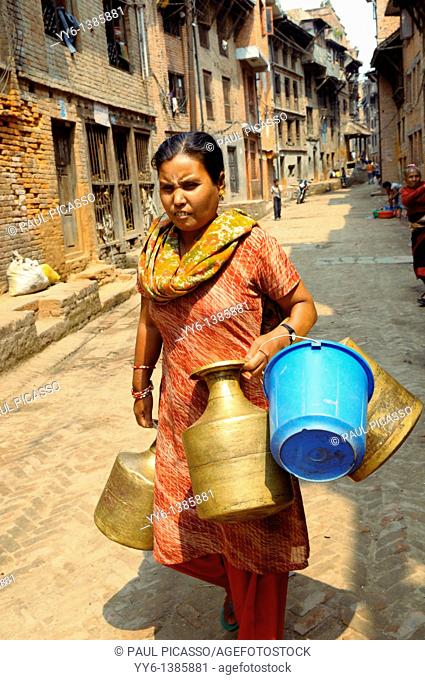 nepalese lady going to collect water , the nepalis , life in kathmandu , kathmandu street life , nepal