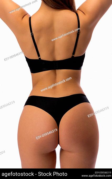 Girl in black underwear. View from the back. Isolate on white background