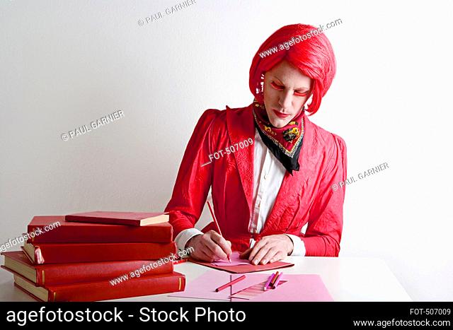 Drag queen sitting at desk
